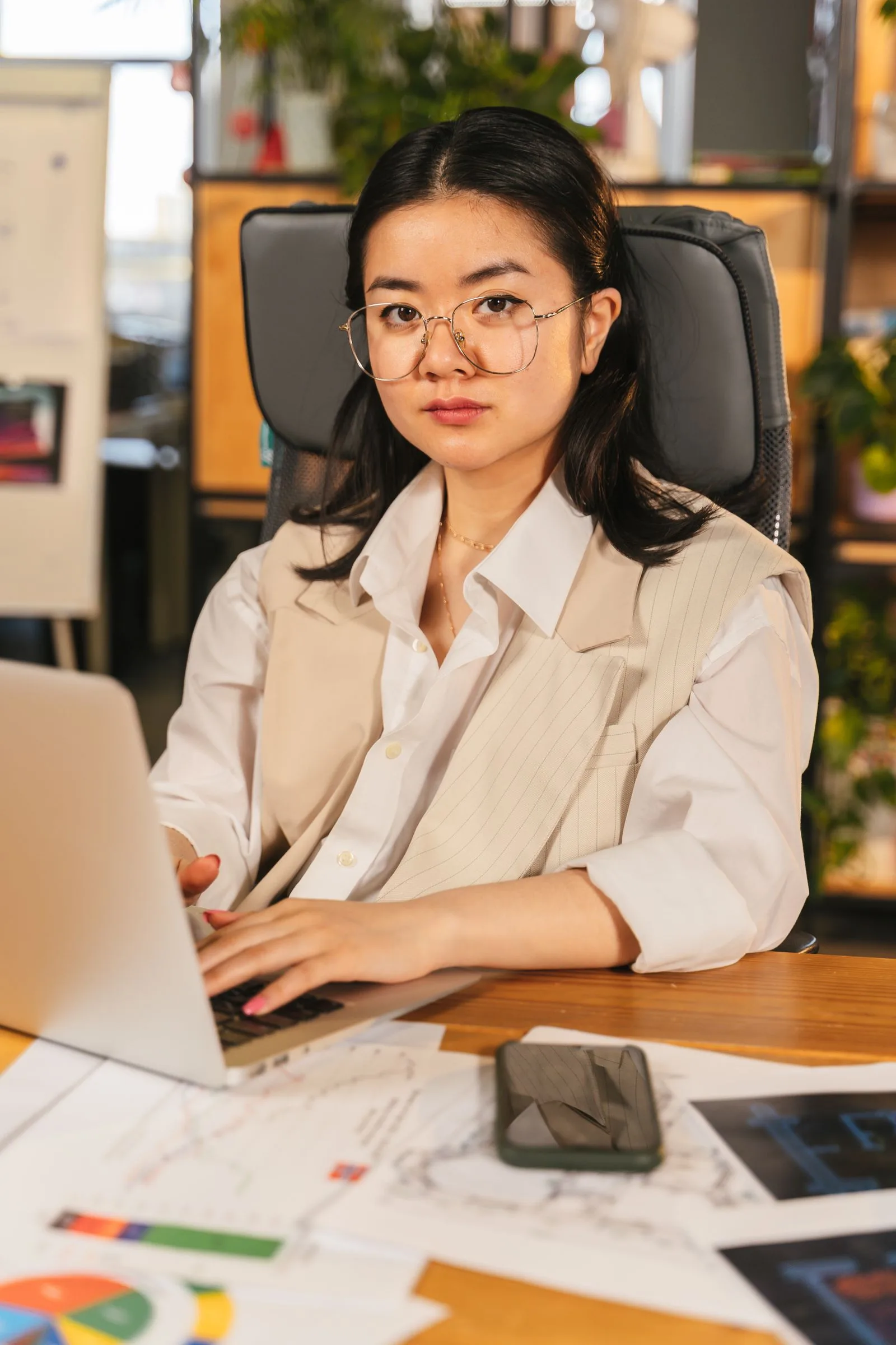 Professional at laptop desk analyzing and working on documents