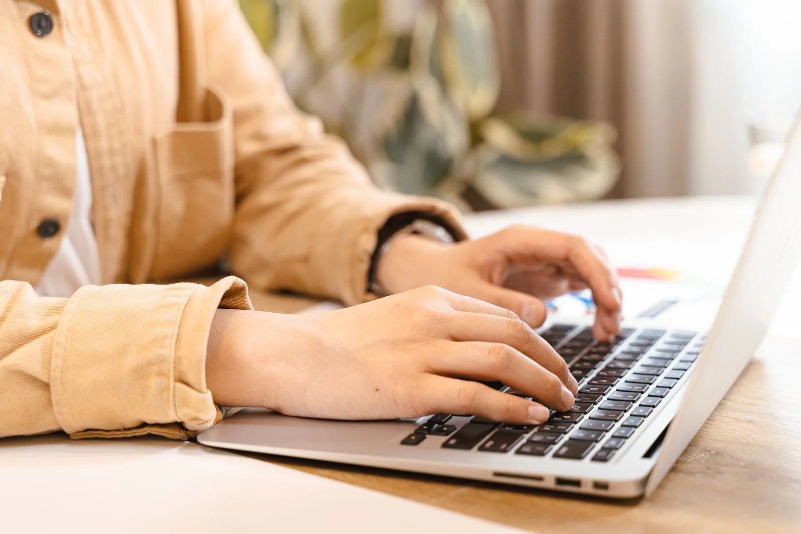 Person carefully typing and editing a resume on a laptop at a desk