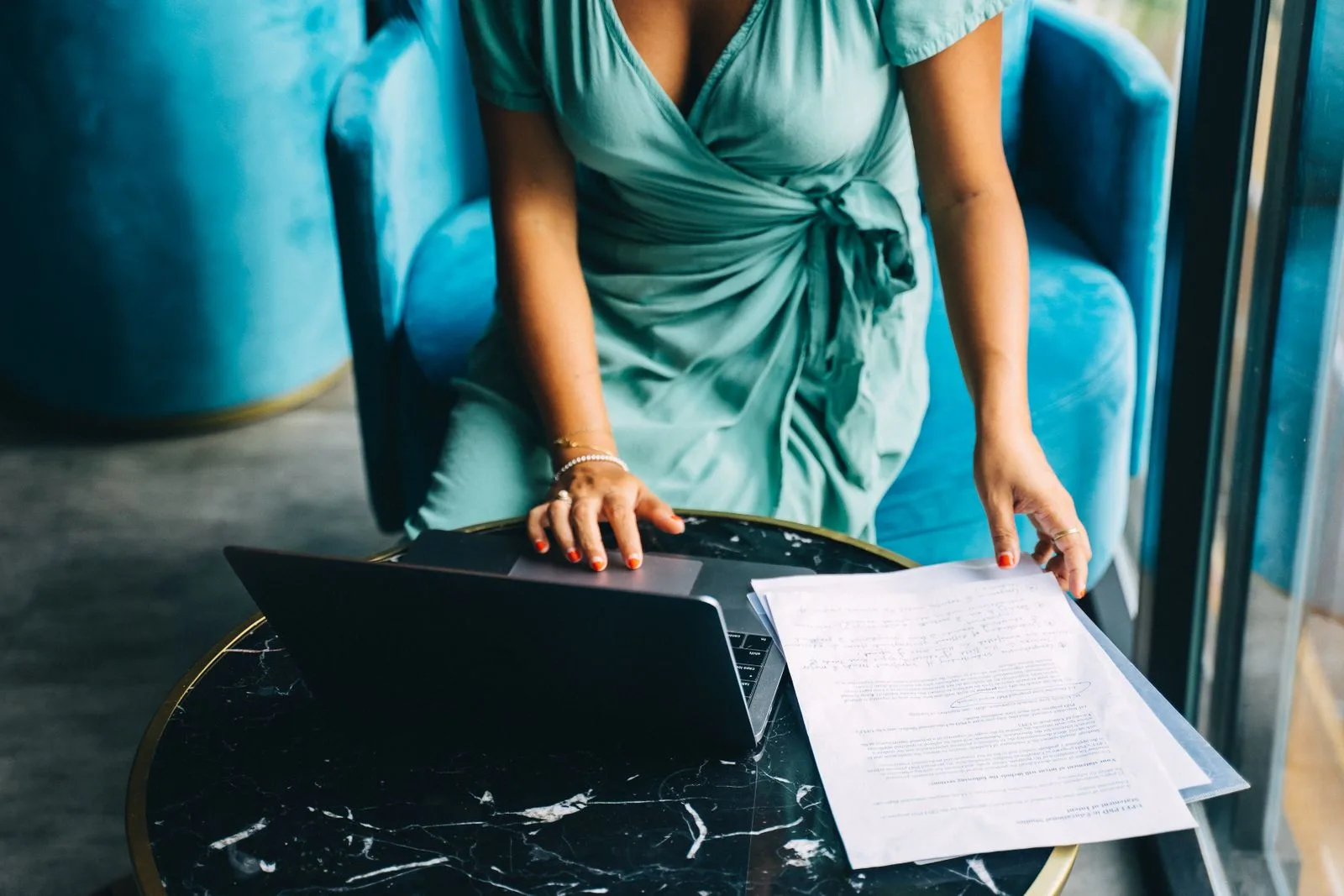 Recruiter reviewing a printed resume next to an open laptop in an office
